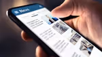 A close up of someone holding a mobile phone and scrolling through articles in a newsfeed