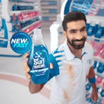 A man holding a bottle of Surf excel Matic Express detergent against a store aisle background. A "New & Fast" label is shown beside him.